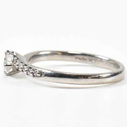 425 - A hallmarked 18ct white gold and diamond crossover ring. The ring set with a central button claw set... 