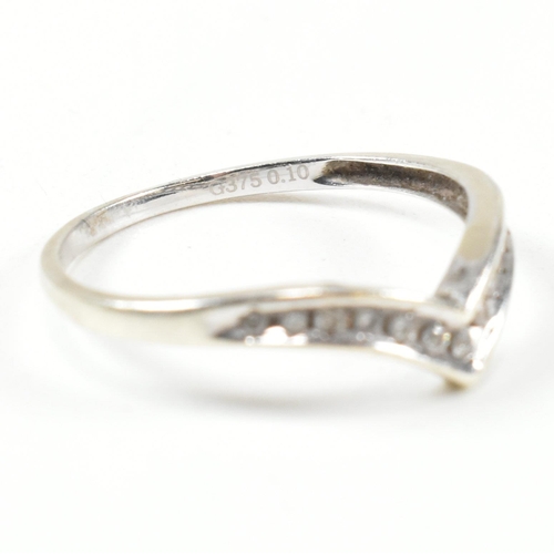 426 - A hallmarked 9ct white gold and diamond wish bone ring. The wishbone ring set with a row of graduati... 