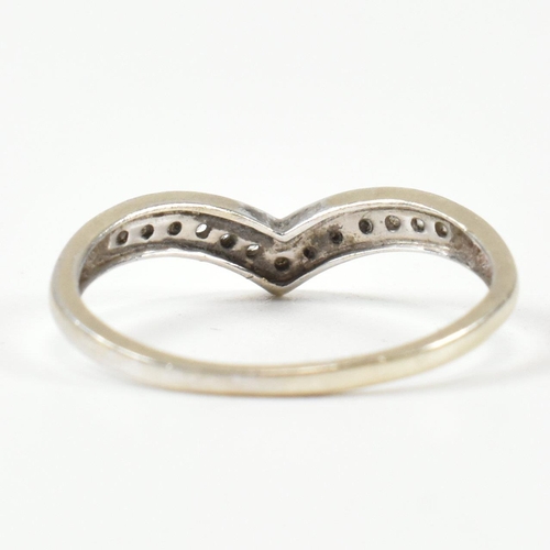 426 - A hallmarked 9ct white gold and diamond wish bone ring. The wishbone ring set with a row of graduati... 