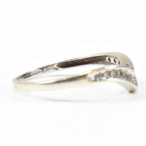 426 - A hallmarked 9ct white gold and diamond wish bone ring. The wishbone ring set with a row of graduati... 