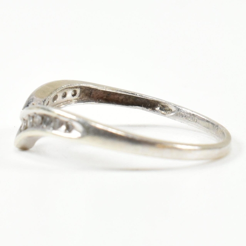 426 - A hallmarked 9ct white gold and diamond wish bone ring. The wishbone ring set with a row of graduati... 