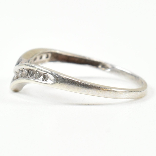 426 - A hallmarked 9ct white gold and diamond wish bone ring. The wishbone ring set with a row of graduati... 