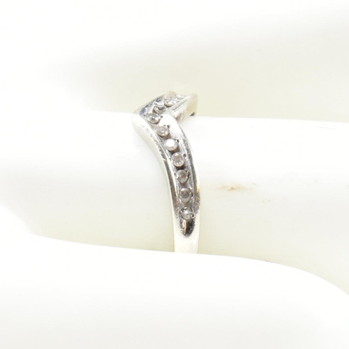 426 - A hallmarked 9ct white gold and diamond wish bone ring. The wishbone ring set with a row of graduati... 