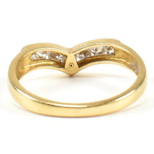 428 - A hallmarked 18ct gold and diamond wishbone ring. The wishbone ring set with a row of seven channel ... 