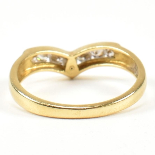 428 - A hallmarked 18ct gold and diamond wishbone ring. The wishbone ring set with a row of seven channel ... 