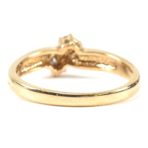 435 - A hallmarked 9ct gold and diamond crossover ring. The ring having two illusion set round cut diamond... 