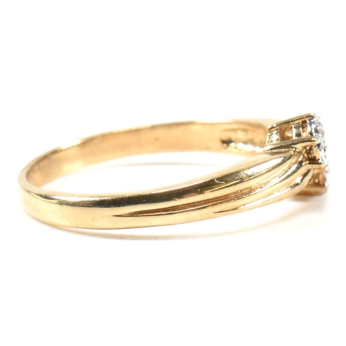 435 - A hallmarked 9ct gold and diamond crossover ring. The ring having two illusion set round cut diamond... 