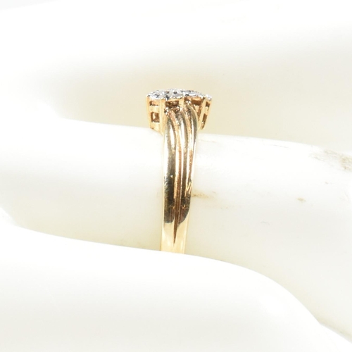 435 - A hallmarked 9ct gold and diamond crossover ring. The ring having two illusion set round cut diamond... 