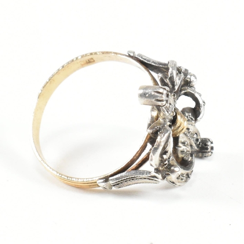 436 - A Fleur de lis diamond cluster ring. The ring having a diamond set a fleur de lis motif to ribbed ba... 