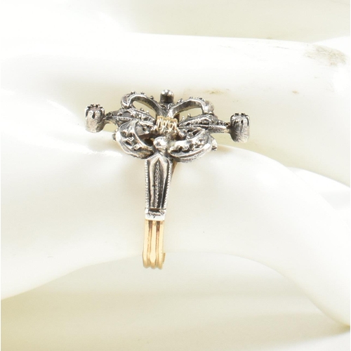 436 - A Fleur de lis diamond cluster ring. The ring having a diamond set a fleur de lis motif to ribbed ba... 