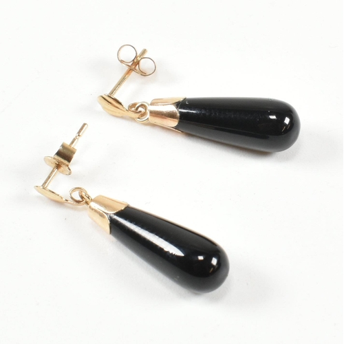 441 - A pair of 9ct gold and black glass pendant earrings. The earrings having a black glass pendant surmo... 