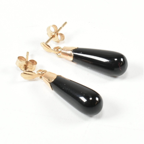 441 - A pair of 9ct gold and black glass pendant earrings. The earrings having a black glass pendant surmo... 