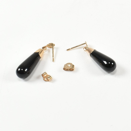 441 - A pair of 9ct gold and black glass pendant earrings. The earrings having a black glass pendant surmo... 