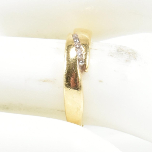 442 - An 18ct gold and diamond crossover band ring. The ring set with five channel set round cut diamonds ... 