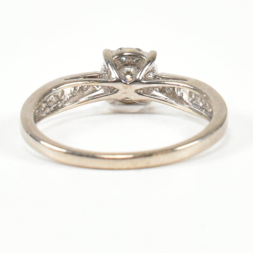 444 - A hallmarked 9ct gold and diamond halo ring. The ring having a central round brilliant cut diamond s... 