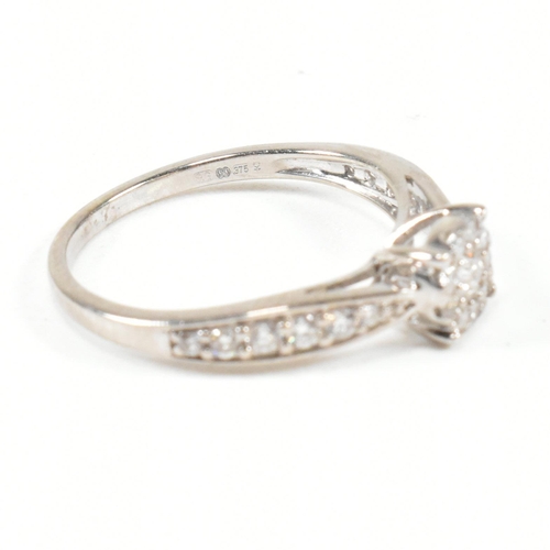 444 - A hallmarked 9ct gold and diamond halo ring. The ring having a central round brilliant cut diamond s... 