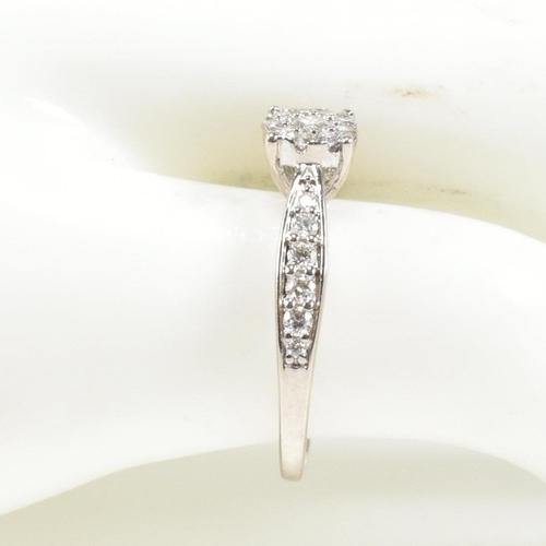 444 - A hallmarked 9ct gold and diamond halo ring. The ring having a central round brilliant cut diamond s... 