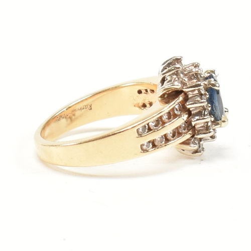 450 - A 14ct gold sapphire and diamond cluster ring. The ring set with an oval cut sapphire framed by roun... 