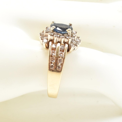 450 - A 14ct gold sapphire and diamond cluster ring. The ring set with an oval cut sapphire framed by roun... 