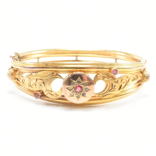 453 - A 19th century gold gem and diamond set hinged bangle. The bangle set with a central gem framed by a... 