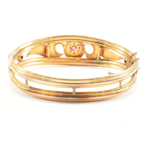 453 - A 19th century gold gem and diamond set hinged bangle. The bangle set with a central gem framed by a... 