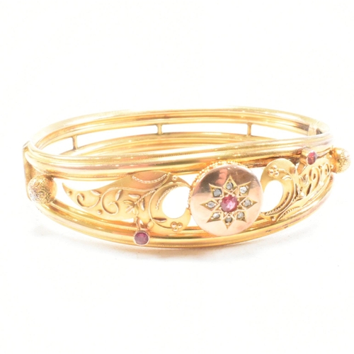 453 - A 19th century gold gem and diamond set hinged bangle. The bangle set with a central gem framed by a... 