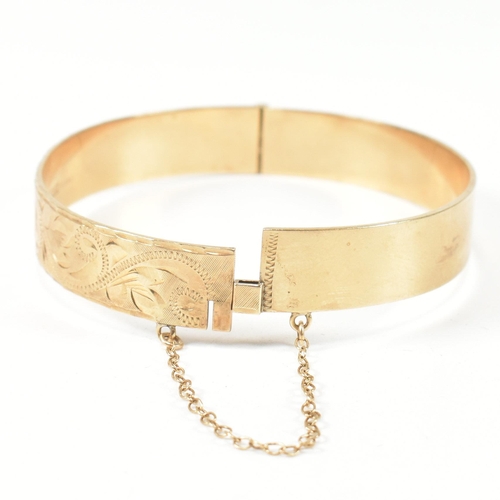 57 - A hallmarked 9ct gold hinged bangle and a pair of 9ct gold hoop earrings. The lot to include a hallm... 