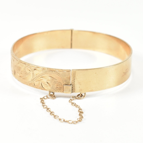 57 - A hallmarked 9ct gold hinged bangle and a pair of 9ct gold hoop earrings. The lot to include a hallm... 