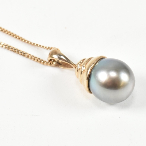 58 - A hallmarked 9ct gold and black pearl pendant necklace. The 9ct gold curb link chain necklace strung... 