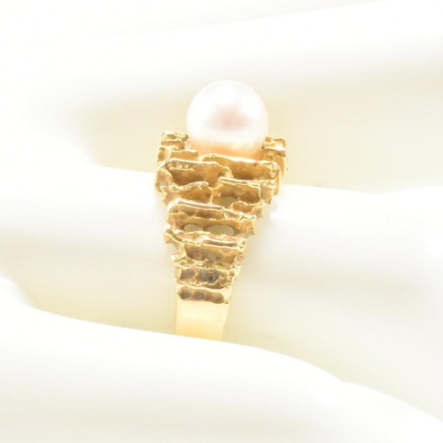 74 - A vintage 18ct yellow gold and pearl dress ring. The brutalist style ring having a pierced bark effe... 