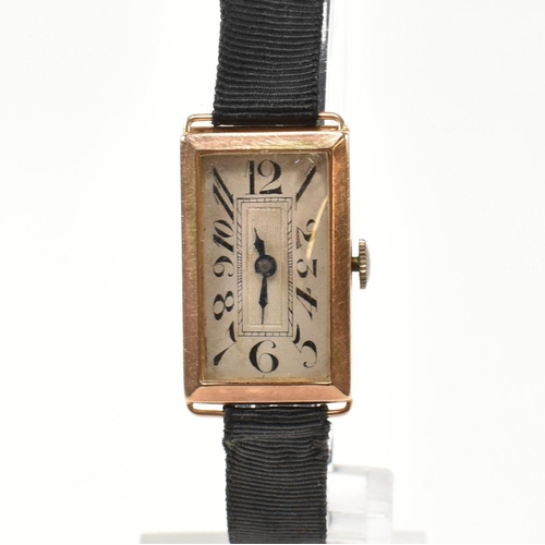 79 - A hallmarked 9ct gold dress watch. The watch having a tank face with elongated dial on fabric strap.... 