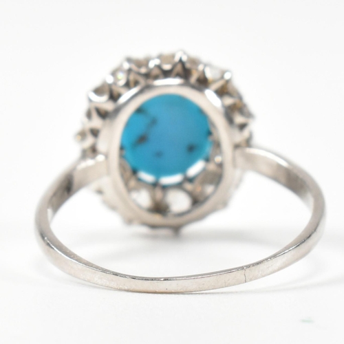 86 - A platinum, turquoise and diamond cluster ring. The ring having a central oval cut cabochon of turqu... 