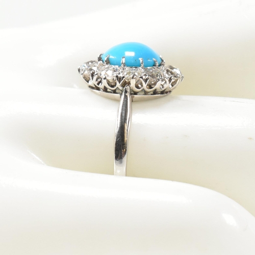 86 - A platinum, turquoise and diamond cluster ring. The ring having a central oval cut cabochon of turqu... 