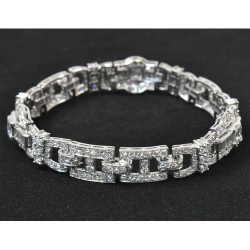 9 - An Art Deco platinum and diamond bracelet. The bracelet having geometric diamond set links to clip c... 