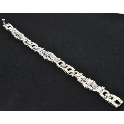 9 - An Art Deco platinum and diamond bracelet. The bracelet having geometric diamond set links to clip c... 