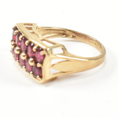 90 - A hallmarked 9ct gold and garnet ring. The ring set with two rows of five oval cut garnets in a rect... 