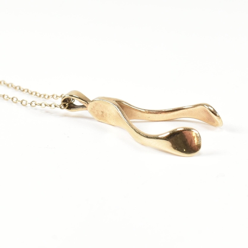 96 - A hallmarked 9ct gold wishbone pendant necklace. The 9ct gold wishbone pendant strung on a 9ct gold ... 