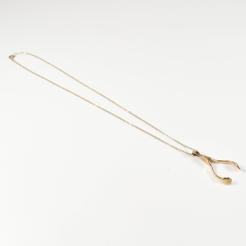 96 - A hallmarked 9ct gold wishbone pendant necklace. The 9ct gold wishbone pendant strung on a 9ct gold ... 