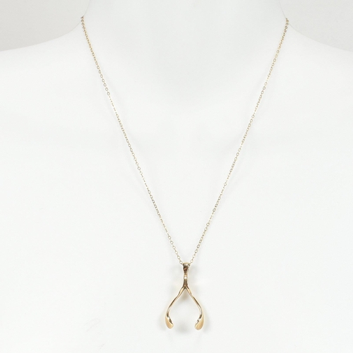 96 - A hallmarked 9ct gold wishbone pendant necklace. The 9ct gold wishbone pendant strung on a 9ct gold ... 