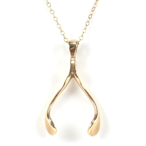 96 - A hallmarked 9ct gold wishbone pendant necklace. The 9ct gold wishbone pendant strung on a 9ct gold ... 