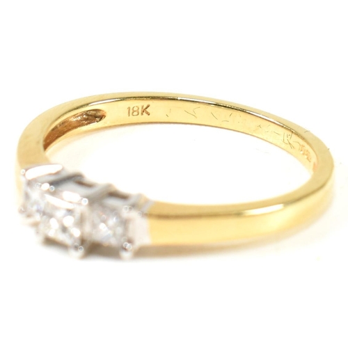 97 - A hallmarked 18ct gold and diamond three stone ring. The ring set with three princess cut diamonds t... 