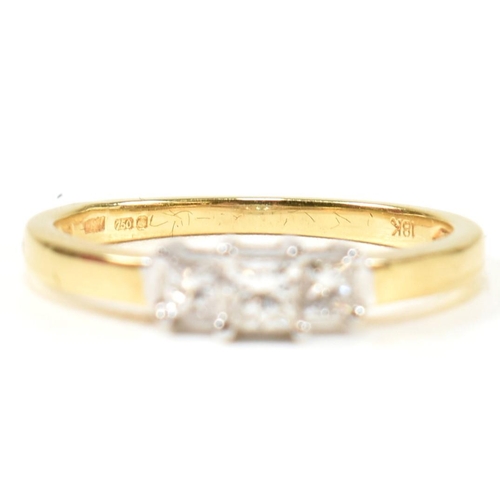 97 - A hallmarked 18ct gold and diamond three stone ring. The ring set with three princess cut diamonds t... 