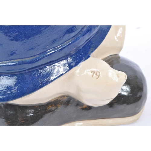 107 - A 20th Century vintage ceramic money box figure in the form of a pig's head sat upon large boots, we... 