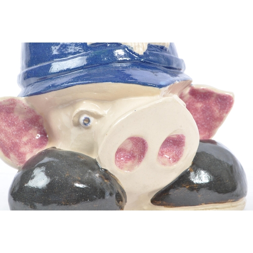 107 - A 20th Century vintage ceramic money box figure in the form of a pig's head sat upon large boots, we... 