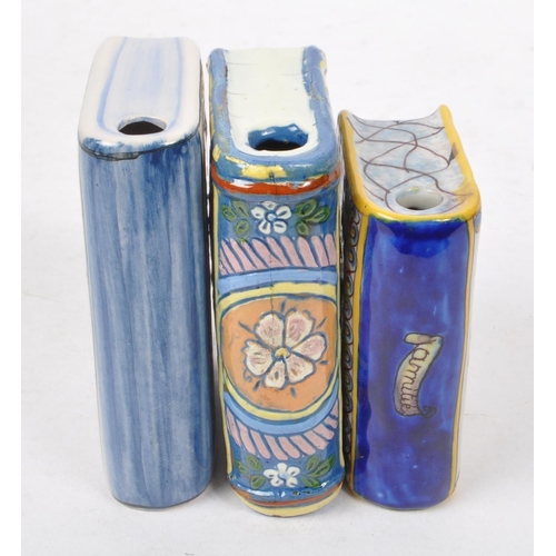 125 - A collection of three ceramic hand painted bottles in the form of books, one having ' Mont St Michel... 