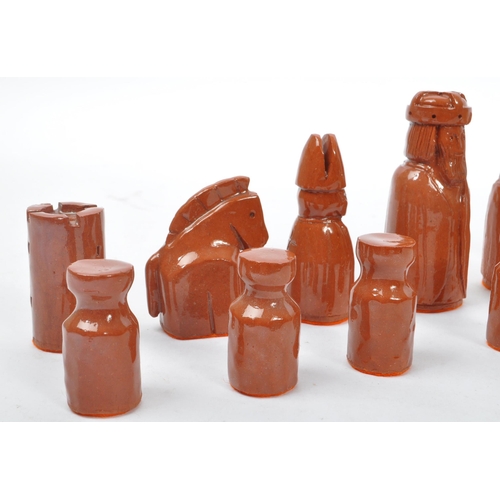 161 - A ceramic handmade terracotta and stoneware colouring chess set with glazed finish and orange felt t... 