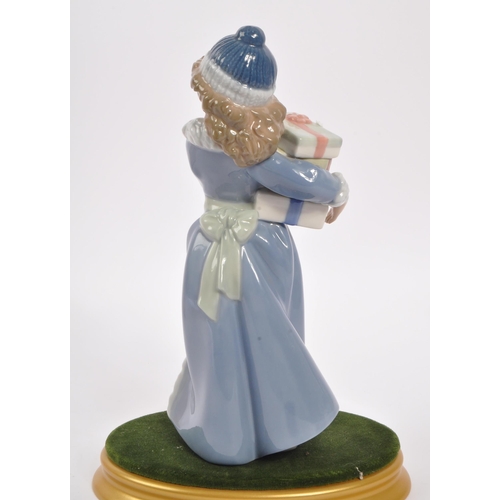 182 - Nao by Lladro - A 20th Century china porcelain Nao by Lladro ' Christmas Time ' figurine of girl in ... 