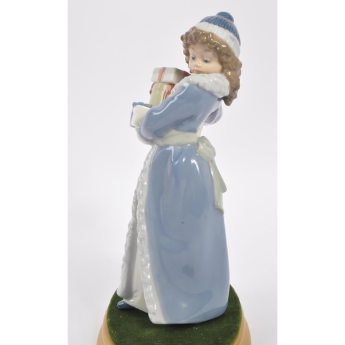 182 - Nao by Lladro - A 20th Century china porcelain Nao by Lladro ' Christmas Time ' figurine of girl in ... 