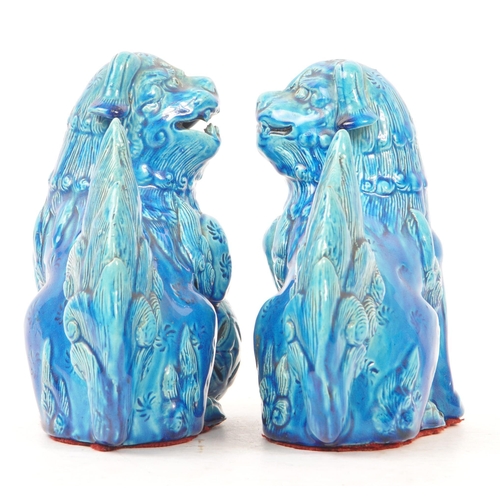 198 - A pair of vintage 20th century ceramic pottery temple guardian Fu dogs. In blue colourway, with paw ... 