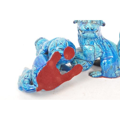 198 - A pair of vintage 20th century ceramic pottery temple guardian Fu dogs. In blue colourway, with paw ... 